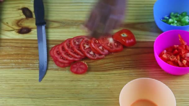 Vista superior en manos de hombre de piel oscura rebanada por cuchillo tomate rojo maduro grande — Vídeo de stock