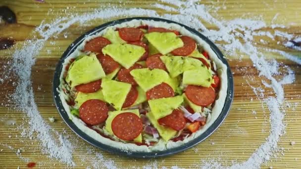 Zooma ut från rå pizza med pepperoni, bacon, grönsaker och ananas skivor — Stockvideo