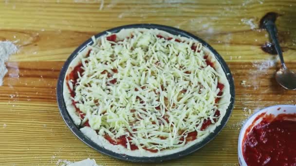 Adamın üst görüntüsü kırmızı biber parçalarını soslu ve peynirli çiğ pizzaya koydu. — Stok video