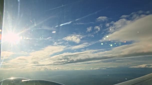 Vista aérea da janela do avião em nuvens brancas fofas voam rapidamente no céu azul — Vídeo de Stock