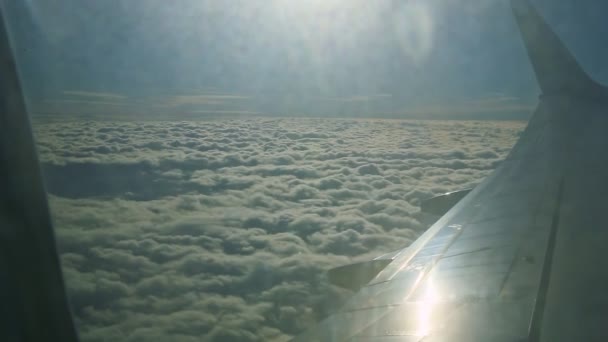 Légi felvétel a repülőgép ablakából nagy acél szárny felett repülnek bolyhos fehér felhők — Stock videók