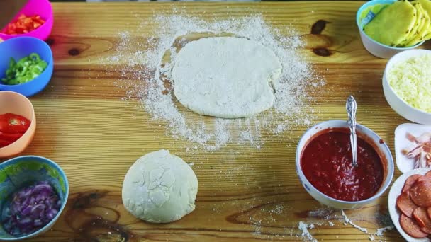 En üstteki adam elleriyle ahşap masada pizza hamuru yapıyor. — Stok video