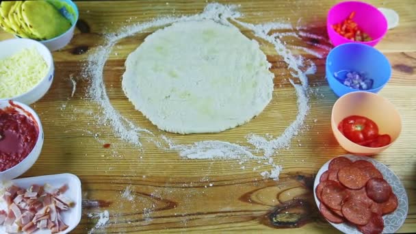 Vue de dessus sur cuisinier par les mains met pâte à pizza roulée sur plat de cuisson rond en acier — Video