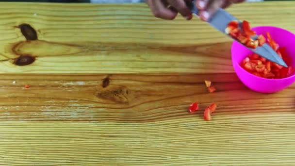 Vista dall'alto sulle mani dell'uomo da coltello mette tritato peperoncino rosso in ciotola rosa — Video Stock