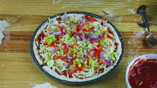 Top view closeup man by hands put tomatoes slices on raw pizza with many ingredients — Stock Video