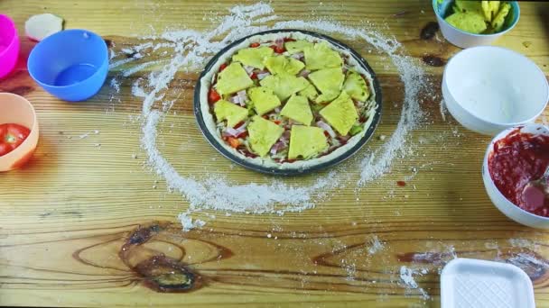 Vista dall'alto su uomo da mani mette fette di salame piccante a pizza semilavorata con ananas — Video Stock