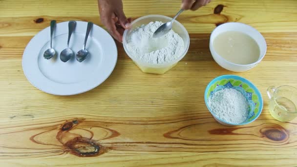 Vue de dessus sur les mains de l'homme faisant l'approfondissement par cuillère dans de la farine blanche servie dans un bol — Video