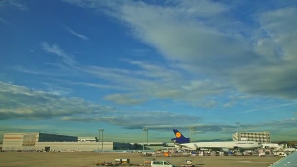 Αργά πανόραμα για τα αεροσκάφη κοντά σε νέους τερματικούς σταθμούς του αεροδρομίου με μπλε γυαλί στη Φρανκφούρτη — Αρχείο Βίντεο