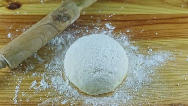 Perlahan-lahan zoom out dari adonan segar disajikan di samping rolling pin di atas meja kayu — Stok Video