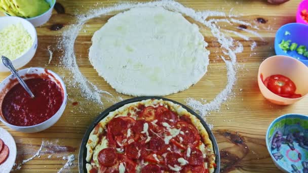 Top view at round dough with oil drops served next to ready baked pizza on table — Stock Video