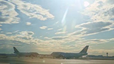 Büyük uçaklar Almanya 'daki Frankfurt havaalanındaki uçak pistinde yavaşça hareket ediyor.