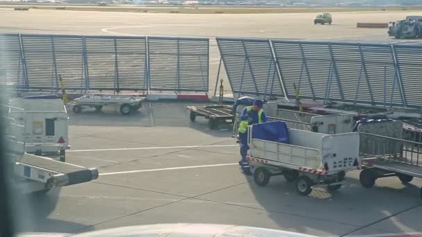 Airport worker ready to take luggage on transportation cart at Frankfurt airfield — Stock Video