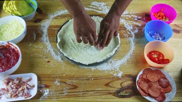 A visão superior no homem por mãos forma bordas da massa de pizza na assadeira redonda de aço — Vídeo de Stock