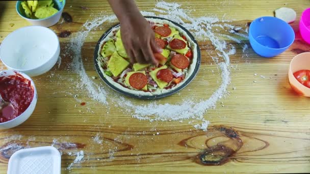 Top view on man by hands put pepperoni skivor på rå pizza med olika ingredienser — Stockvideo