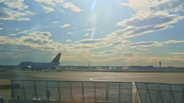 Büyük uçaklar Almanya 'daki Frankfurt havaalanındaki uçak pistinde yavaşça hareket ediyor.