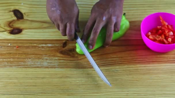 Widok z góry na ciemnoskórego człowieka ręce kroić nożem duży zielony słodki pieprz — Wideo stockowe