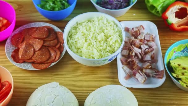 Uitzoomen van verschillende ingrediënten voor het maken van pizza geserveerd op houten tafel — Stockvideo