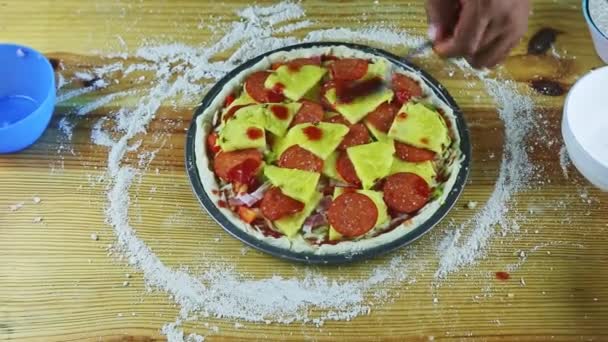 Vista superior en las manos del hombre por cuchara poner salsa de tomate en pizza cruda con pepperoni — Vídeos de Stock