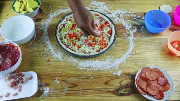 Widok z góry na ręce człowieka umieścić kawałki cebuli na półfabrykatów pizzy z sosem i serem — Wideo stockowe