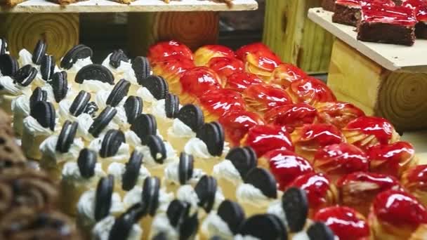 Медленно панорама на ассортимент различных кусочков сладкого торта и фруктовых эклеров — стоковое видео