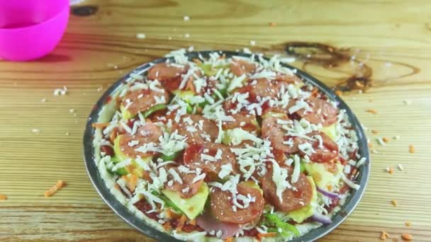 Widok z góry zbliżenie na ręce człowieka umieścić tarty twardy ser na pizzy z sosem pomidorowym — Wideo stockowe