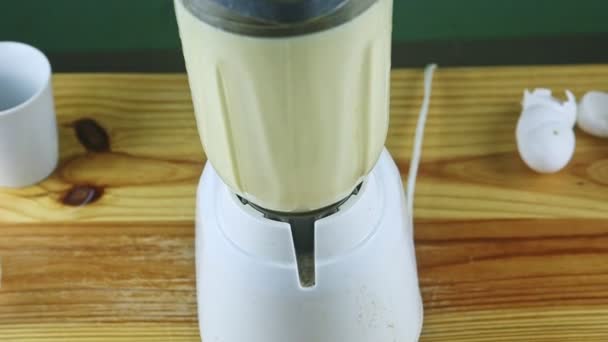 Vista superior de la licuadora eléctrica que mezcla leche, leche condensada y huevos — Vídeo de stock