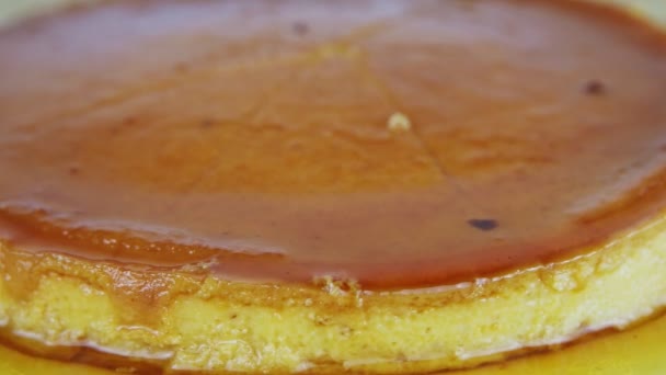 Zooma ut från hela rundan hemmagjord mjuk flan med karamell sirap på vit platta — Stockvideo
