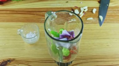 Erkek ellerine zum yap cam blender kadehine doğranmış sebzelerle sarımsak koy.