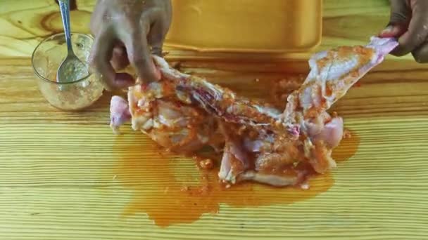 Top view close-up man door handen neemt de helft van de rauwe kip gemarineerd in knoflooksaus — Stockvideo