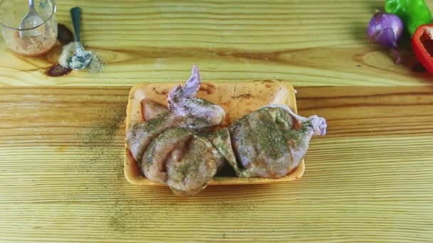 Top view zoom in at half of raw chicken in oregano served with onion and paprika — Stock Video