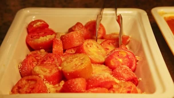 Zbliżenie w głębokiej białej misce serwowane z krojonym pomidorem z tartym topionym serem — Wideo stockowe