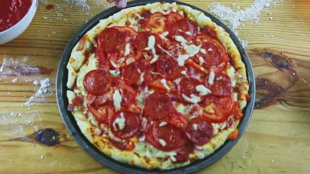 Erkek ellerinin üst görüntüsü. Çiğ pizzaya farklı malzemelerle pepperoni dilimleri koyun. — Stok video