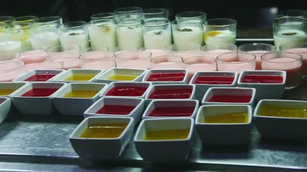 Gyors panoráma a nagy választéka gyümölcskocsonya és színes joghurt az élelmiszer bíróság — Stock videók