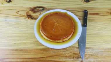 Karamel şurubuyla dilimlenmiş yumuşak süt turtasının üst görüntüsünü yavaşça büyüt