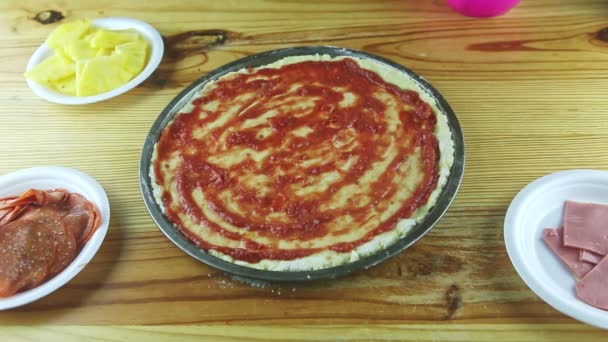 Top view closeup on man hands put grated hard cheese on pizza with tomato sauce — Stock Video