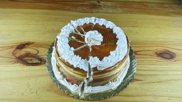 Vue du haut zoomer lentement sur le gâteau au caramel rond tranché décoré de crème blanche — Video