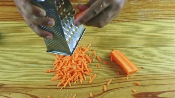 Vista superior closeup homem mãos ralar pequena paz de cenoura fresca no ralador de metal — Vídeo de Stock