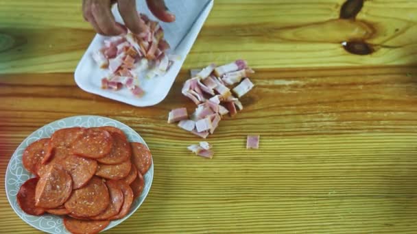 Vista superior em mãos de homem cortadas por faca grande fatia de bacon na mesa de madeira — Vídeo de Stock