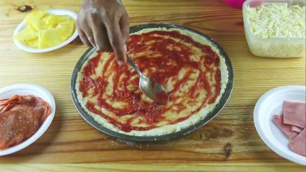 Erkeğin ellerine kaşıkla yukarıdan bak. Yarı bitmiş pizzaya domates sosu koy. — Stok video