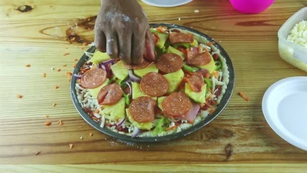 Closeup man by hands put pepperoni slices on raw pizza with many ingredients — Stock Video