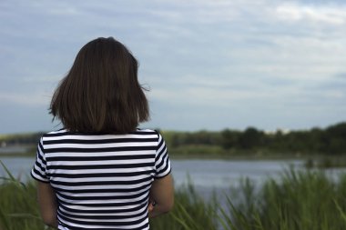 Bir genç kadın standları bir kamış ve bir göl yakınında. Yaz kavramı, metin için yer