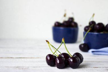 Karanlık-çilek derin tabak içinde olgun kiraz mavi bir kase. Meyveler, vejetaryen yemek