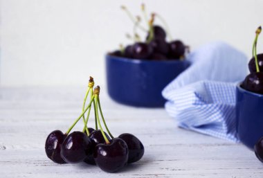 Karanlık-çilek derin tabak içinde olgun kiraz mavi bir kase. Meyveler, vejetaryen yemek