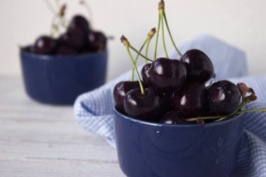 Karanlık-çilek derin tabak içinde olgun kiraz mavi bir kase. Meyveler, vejetaryen yemek