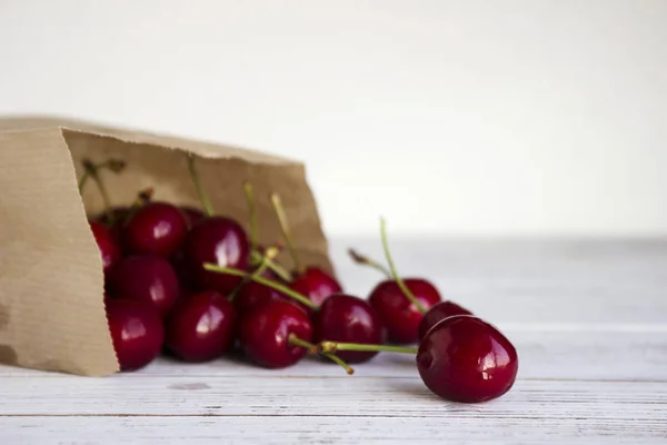 Cerises Mûres Dans Emballage Kraft Papier Sur Fond Bois Blanc — Photo