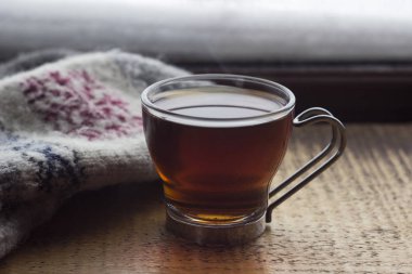 Ahşap arka plan, çay ile cam fincan kapatmak eldiven ile süsleme