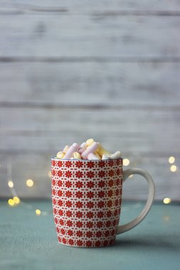 Pembe, sarı ve beyaz hatmi Kupası, üstten görünüm, Noel ışıkları, ahşap arka plan