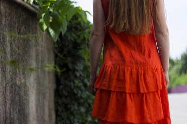 Katlar, yaz, moda ile turuncu çarşaf içinde güzel kadın. Geri kaldırımın üzerinde kızdır