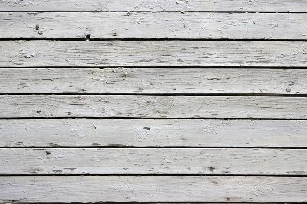 White wood background. Scratched white paint on a wooden plank w