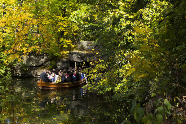 Uman, Ukraine - October 13, 2019: Tunnel, cave under water in the park Sofiyivka Uman. Artificial river excursions in the fall, many beautiful trees